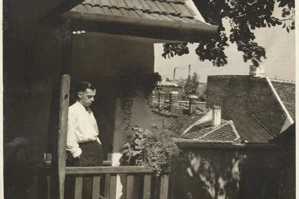 Photographie ancienne tirée d'un album de famille hongrois : un homme en chemise blanche sur le perron d'une maison