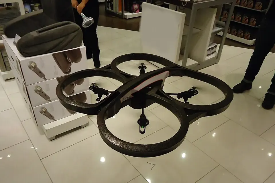 Petit drone de loisir à quatre hélices en vol à faible hauteur au-dessus du sol d'un magasin