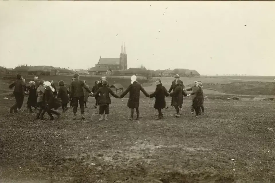 Photographie ancienne en noir et blanc d'enfants jouant dans un champ, un paysage de campagne à l'arrière-plan